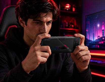 Black Asus ROG Phone 6 5G smartphone held in hands, back facing with light diagonal strip